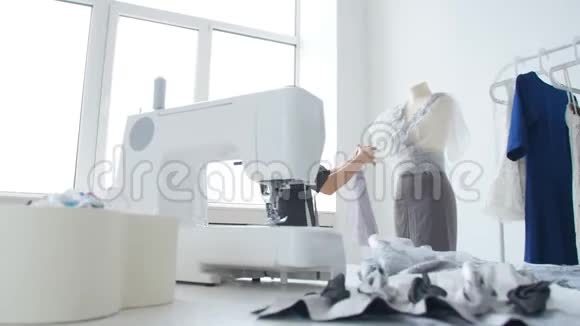 小企业和小生产的概念年轻漂亮的裁缝在车间里缝衣服视频的预览图