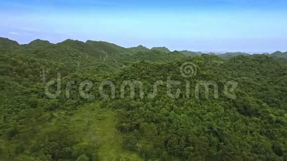 在蓝天下覆盖着丛林的高地上空飞翔视频的预览图