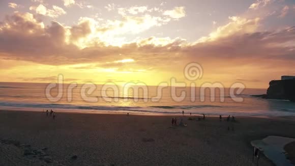 日落时分人们在葡萄牙的阿津哈斯附近的海滩上散步视频的预览图