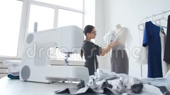 小企业和小生产的概念年轻漂亮的裁缝在车间里缝衣服视频的预览图