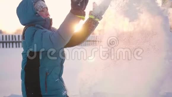 一个孩子在冬天户外玩耍把雪扔到顶部积极的户外运动日落视频的预览图