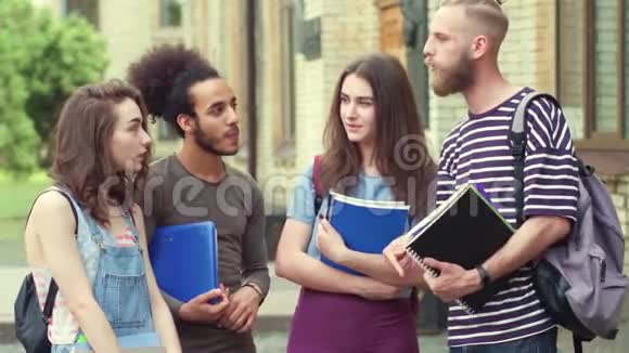 青年学生站在大学门口谈话的录像视频的预览图