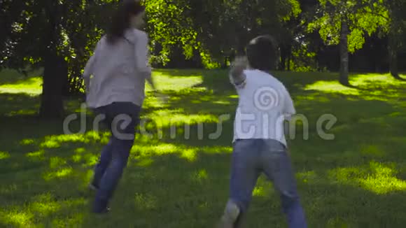妈妈和男孩在草地上玩追赶游戏视频的预览图