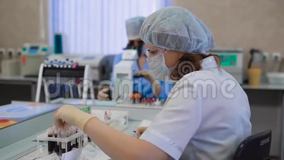女性专科检查血液标本穿着制服的年轻女子坐在桌子上看着标本视频的预览图