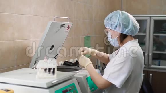 专业女性医疗助理穿白色擦洗防护面罩帽子和乳胶手套带试管视频的预览图
