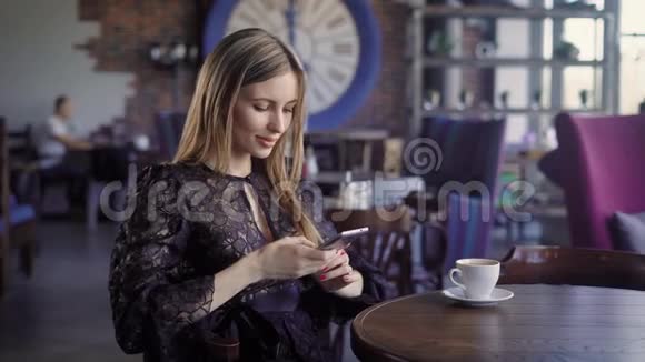 一群穿着黑色连衣裙的女商人正在使用现代智能手机坐在咖啡馆里可爱的女士很放松视频的预览图