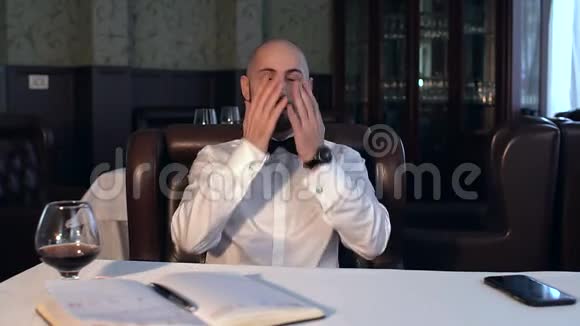 悲伤的商人坐在餐馆里喝白兰地视频的预览图