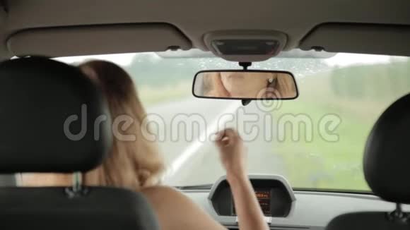 年轻的金发女人用牙线在她的车上的出租车上女人和牙线视频的预览图