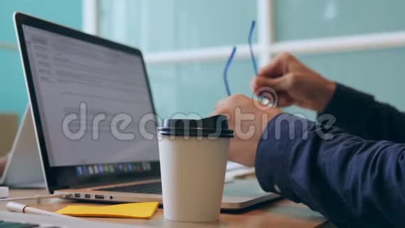 年轻的程序员喝酒把咖啡从纸杯里带走在办公室里工作4特写视频的预览图