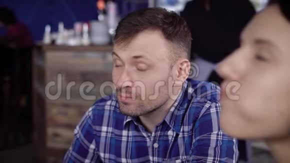一个年轻人和他的朋友坐在餐馆里喝着蓝色杯子里的咖啡学生吃早餐视频的预览图
