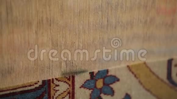 女人缝东方地毯在织布机后面的特写镜头视频的预览图