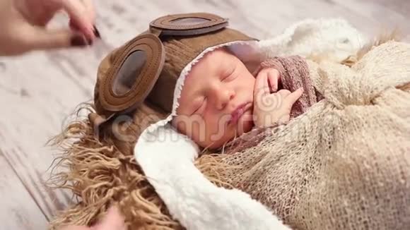 母亲把老式飞行员头盔固定在婴儿身上视频的预览图