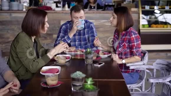 一家成人朋友公司正在吃美味的三明治里面有鱼和蔬菜喝咖啡和牛奶视频的预览图