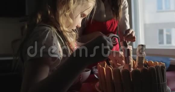一位年轻的母亲和她的小女儿装饰一个生日蛋糕视频的预览图