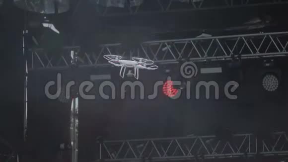 现代无人机四架直升机带着相机飞行在舞台上拍摄一场音乐会视频的预览图