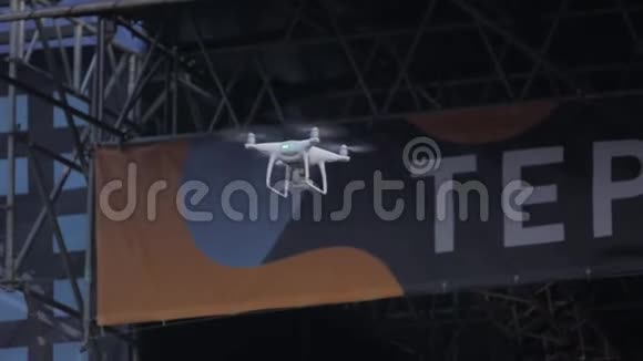 现代无人机四架直升机带着相机飞行在舞台上拍摄一场音乐会视频的预览图