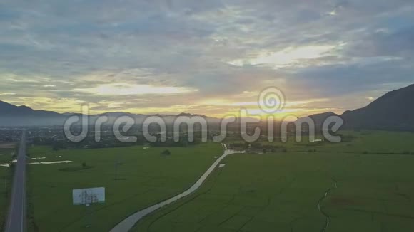 无人机在黎明时分在热带地区展示农村土地和田间公路视频的预览图