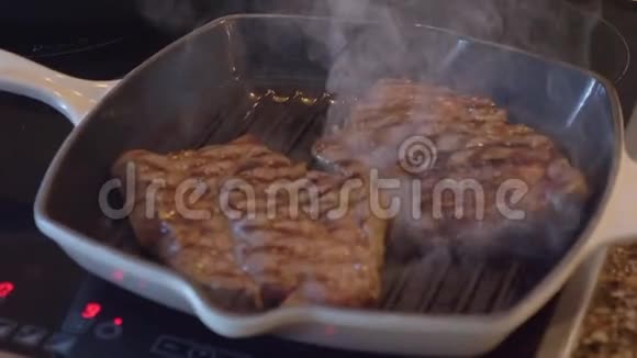 一块牛排在烤盘上煎白烟升起在煎锅上方视频的预览图