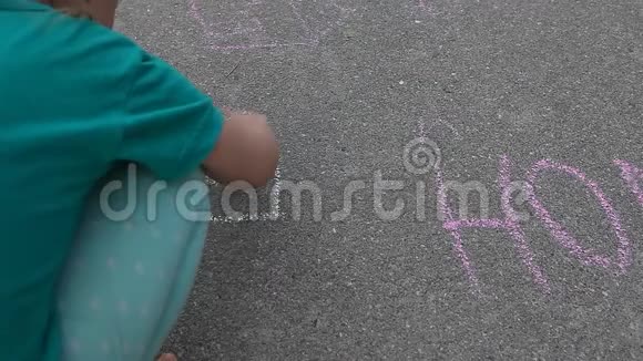 儿童画屋旁边的单词HOME用粉笔在沥青路面上拼写视频的预览图