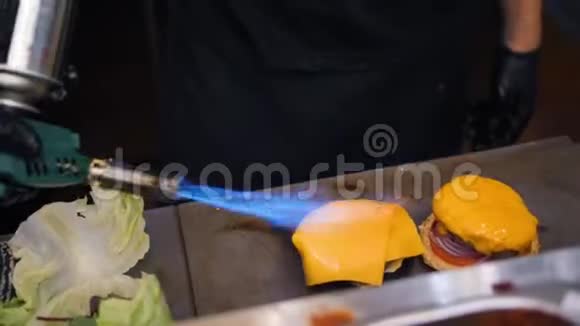厨师融化纯素奶酪使用燃烧炉和制作汉堡在餐厅厨房4K慢动作视频的预览图