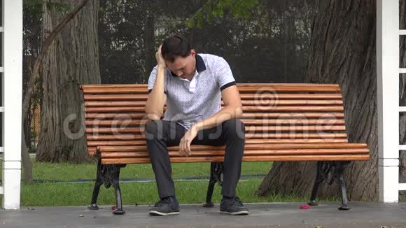 孤独的悲伤者坐在公园里视频的预览图