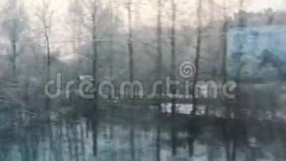 火车从窗口观看冬季雪林村房屋在雪冬天的森林透过窗户视频的预览图