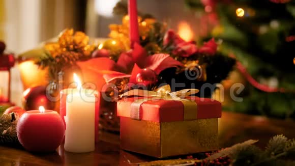 特写4k镜头的礼品盒燃烧蜡烛和传统的圣诞花环在桌子上冬天的完美背景视频的预览图