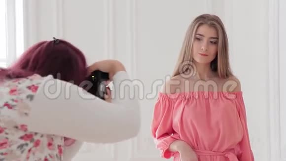 摄影师为模特拍摄浪漫的粉色礼服视频的预览图