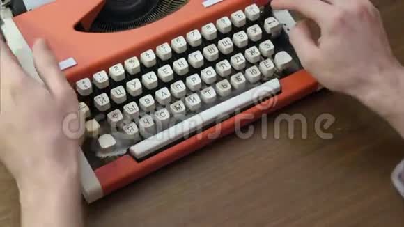 男人用旧的红色机械打字机打字视频的预览图