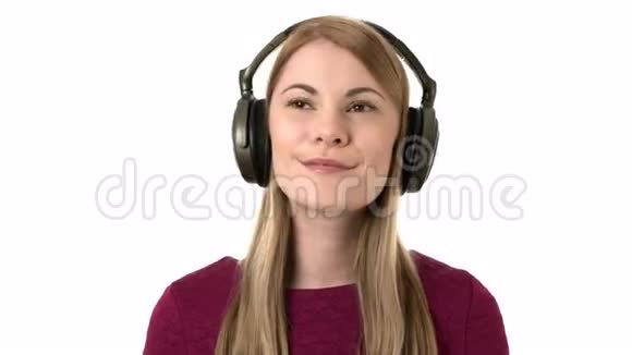 美丽迷人的女人带着耳机梦想地听音乐孤立的白色背景视频的预览图