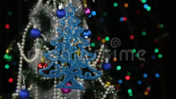 美丽的蓝色新年和圣诞装饰形状像圣诞树在绳子上摆动视频的预览图