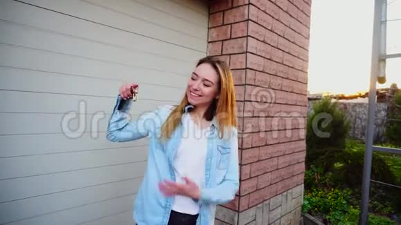 幸福的女孩站在车库附近拿着车钥匙视频的预览图