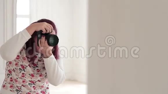 年轻的时髦女人用数码相机拍照视频的预览图