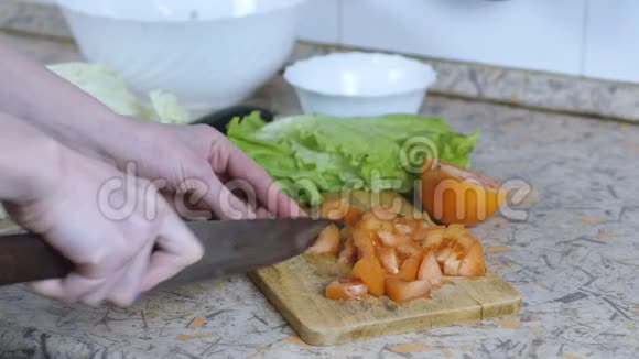无法辨认的女人在厨房桌子上的切割板上把番茄切成小块把手举起来视频的预览图