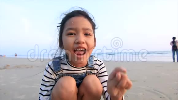 快乐的亚洲小女孩在海滩上玩耍晚上的气氛视频的预览图