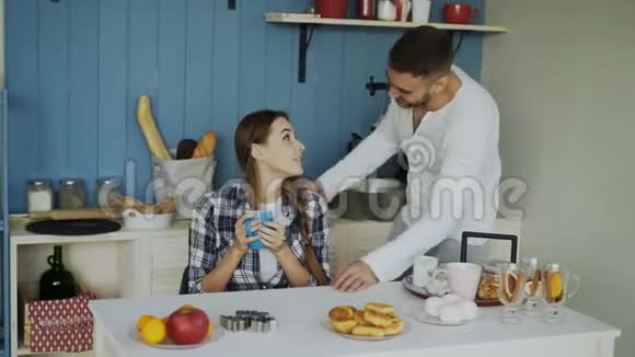 有魅力的一对夫妇在家吃早餐时在厨房里见面接吻视频的预览图