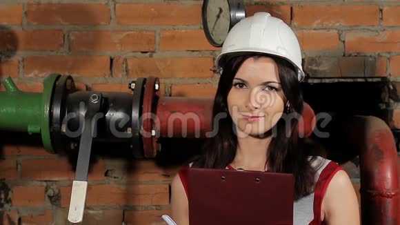 一位美丽的黑发女子白种人工程师笑的肖像一个戴着白色安全帽的女工微笑着反对视频的预览图