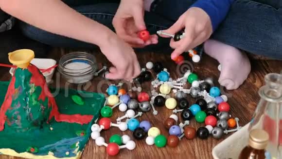 近手妈妈和儿子搭建分子模型的彩色塑料搭建套装视频的预览图