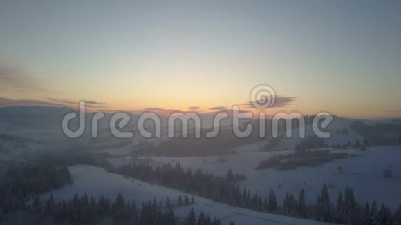 日出时空中北欧冬季景观飞越雪山森林冬季无人驾驶飞机飞越山区视频的预览图