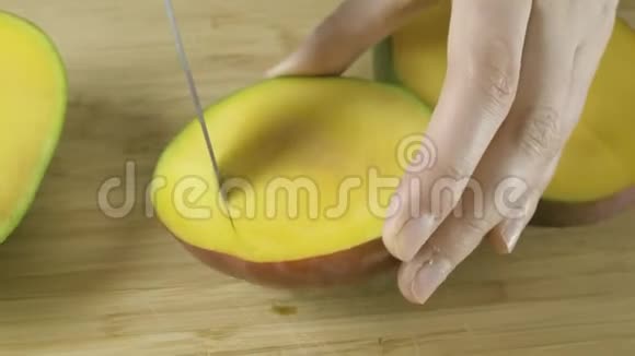 女人的双手展开剪成黄色的芒果慢动作特写4K视频视频的预览图