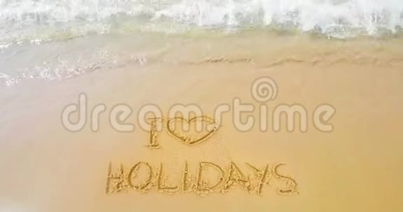 沙滩和热带海浪的金沙在沙滩上写文字我喜欢心形的假期视频的预览图