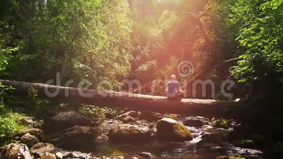 一个人正在一条山河的背景下放松视频的预览图