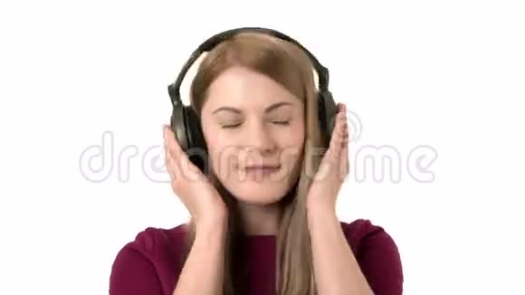 美丽迷人的女人带着耳机听音乐孤立的白色背景在笑视频的预览图