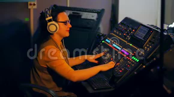 耳机中的DJ在混合控制台上混合迪斯科音乐视频的预览图