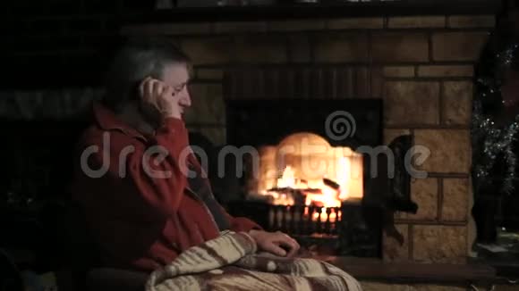 老人在带壁炉的房间里通过电话结束了一次聚会视频的预览图