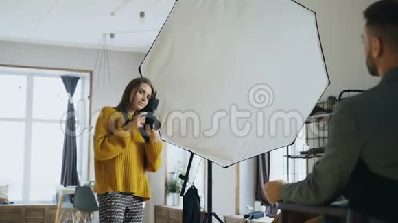 专业摄影师女摄影师在摄影棚用数码相机拍摄商人模特女视频的预览图