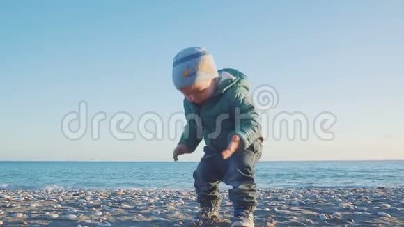 宝宝的生活方式一个男孩在天然海滩上玩沙子和石头与斯泰西卡姆视频的预览图