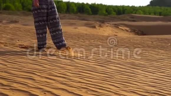 穿着亚洲裤子的年轻女孩在越南梅内的红色沙漠中漫步视频的预览图