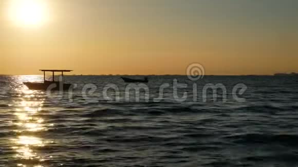 4K日落或日出时小船在海面上随小浪的轮廓美丽的阳光与水面反射视频的预览图