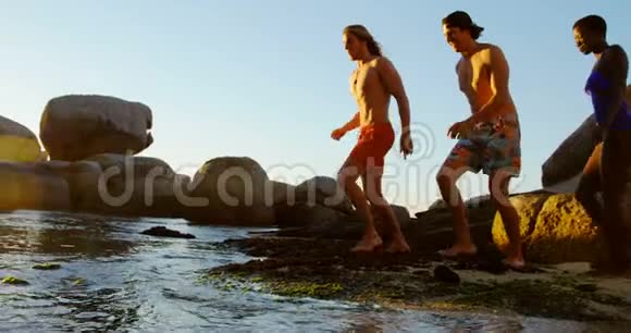 一群朋友在海滩上朝大海跑去视频的预览图